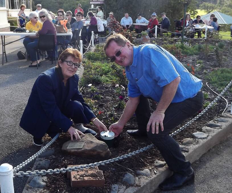 HISTORIC: Sue Brown and Ken Wilson place the time capsule down during the centenary celebrations on Saturday.