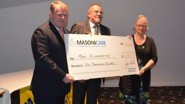 Grand Master of NSW & ACT Freemasons James Melville and District Grand Inspector Mark Pollard present the donation to Elizabeth Berger, CEO of Marli Accommodation Services