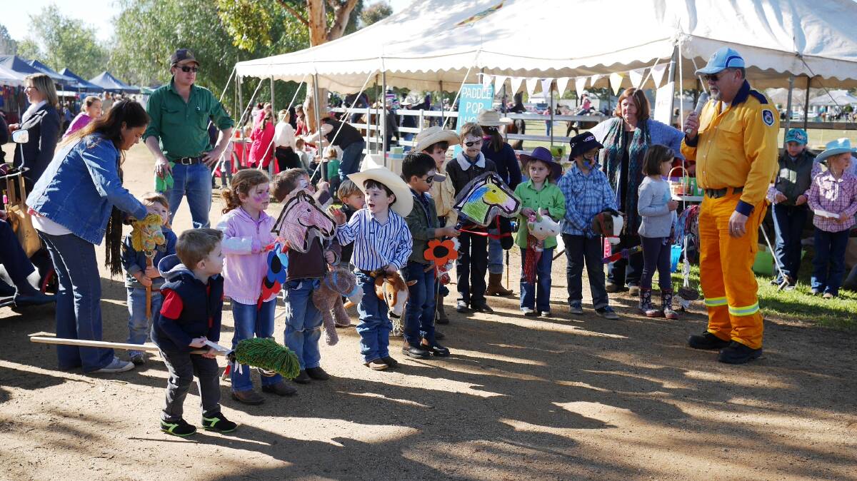 COME ON DOWN: St Joseph’s Merriwa Parents and Friends Junior Campdraft and Fete coordinator Peter Holland gets the “riders” ready for a mad dash down the laneway in the hobby horse race at last year’s fete.