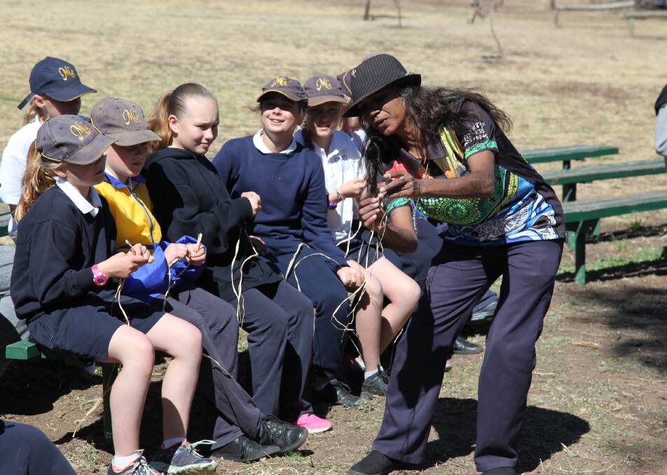 Kamilaroi elder Dolly Jerome shows Merriwa Central School students Mia Morgan, Zali Wallings, Eliza Parker, Ildiko Papp and Alyssa Carrall how to twist grass strands as part of a weaving workshop this month to celebrate Aboriginal culture.