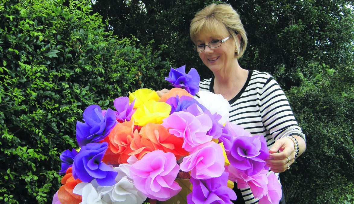 BLOSSOMING: Kathy Floyd with some of the flowers she is making for Red Cross. Flowers will be used to make a Floral Fantasy in the Singleton CWA Hall.