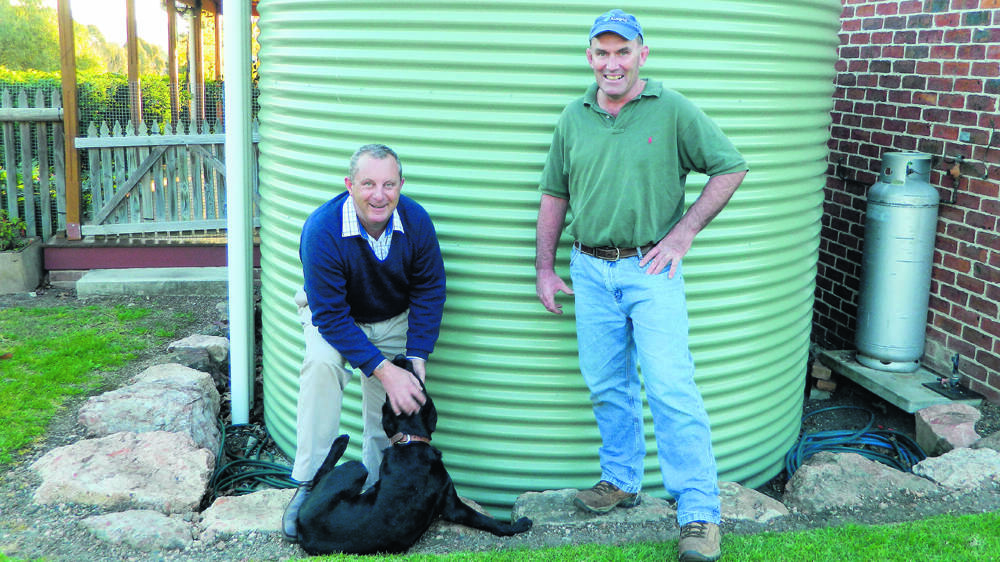 MONEY BACK OFFER: Upper Hunter Shire mayor Michael Johnsen, Marley the labrador and Mick Chesworth of Scone who received a $400 rebate from Upper Hunter Shire Council when he installed his 18,200 litre water tank.
