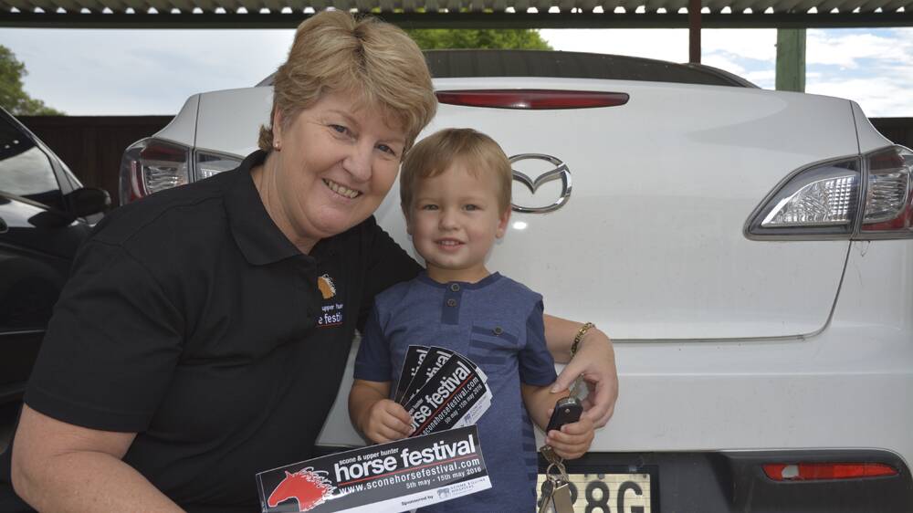 GIDDY UP: Scone and Upper Hunter Horse Festival Committee president Lee Watts and Hudson Presland, 2, with the bumper stickers to promote the event.