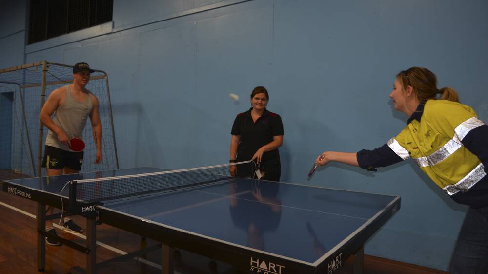 THANKS: Muswellbrook PCYC senior activities assistant Maddy Polzin watches on as member Tye Walklate and environment and community officer at Mangoola Coal Robyn Johnson play a game with the new table tennis set.
