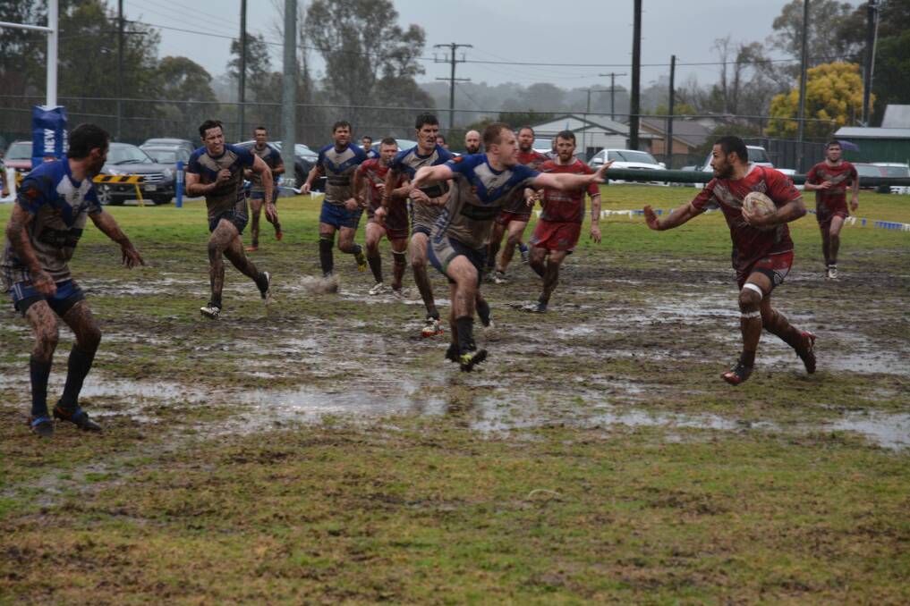 DETERMINED RUN: Singleton Greyhounds centre Daniel Kisi tries to fend off Scone’s Jared Austin during the sides’ reserve grade clash in horrible conditions on the weekend. Pic: BEN MURPHY.
