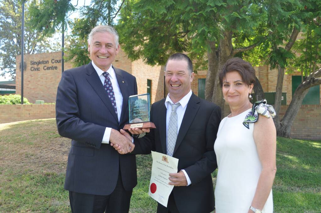 JANUARY: MIXED EMOTIONS:Upper Hunter MP George Souris and his wife Vassy present a humble Graham “Shep” Sheppard, e Singleton CBD caretaker of almost a decade, with his NSW Government Community Service Award at the Australia Day award ceremony.