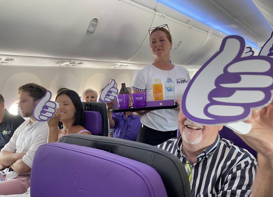 A cabin crew member delivers food on board Bonza's maiden flight. Picture: Sarah Maguire