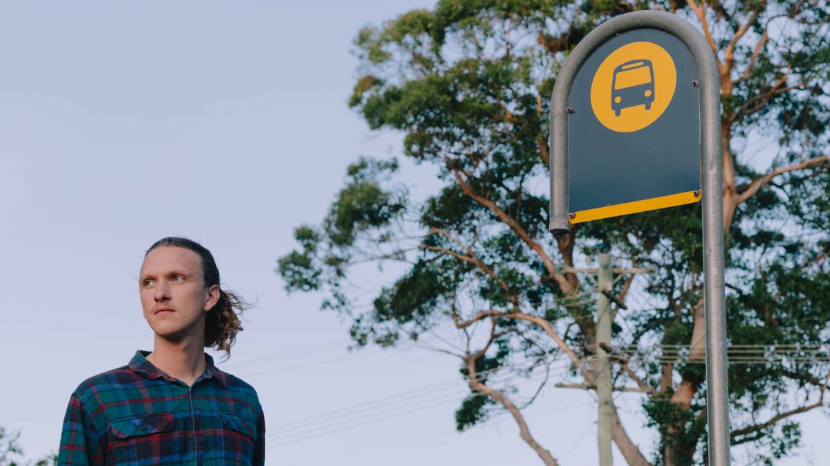James Tugwell, an ACM reporter on the NSW South Coast, waiting at a bus stop in Eurobodalla. Picture by Jake Almeida