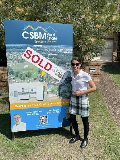 Emma Horn, 30, with a "sold" sign after buying her first home in Thornton in the NSW Hunter Valley. Picture supplied