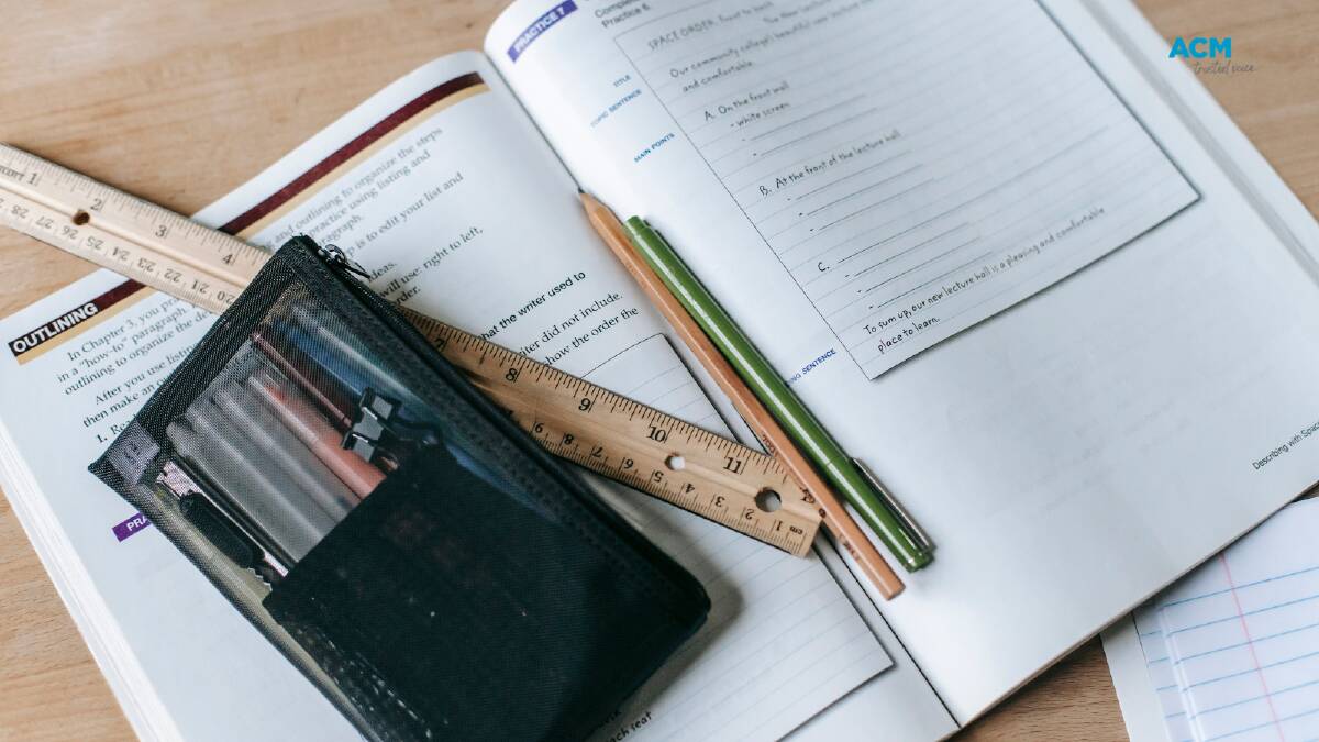 A pencil case and ruler lays on top of an open work book. File picture. 