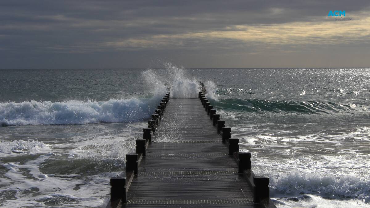 A stormy ocean with waves crashing against a dock. File picture.