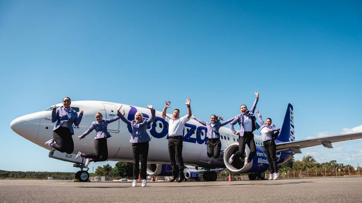 Bonza cabin crew jumping in the air in front of a branded plane. Picture by Bonza