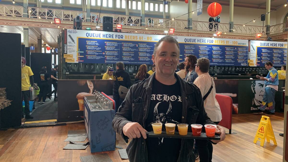 A punter at GABS 2023 with a paddle of beer tasters. Picture by Anna Houlahan