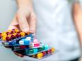 A person holding packets full of colourful pharmaceuticals. Picture: Shutterstock