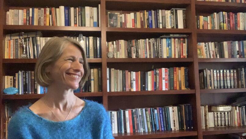 Ros Ben-Moshe in her library wearing a large grin. Picture by Anna Houlahan