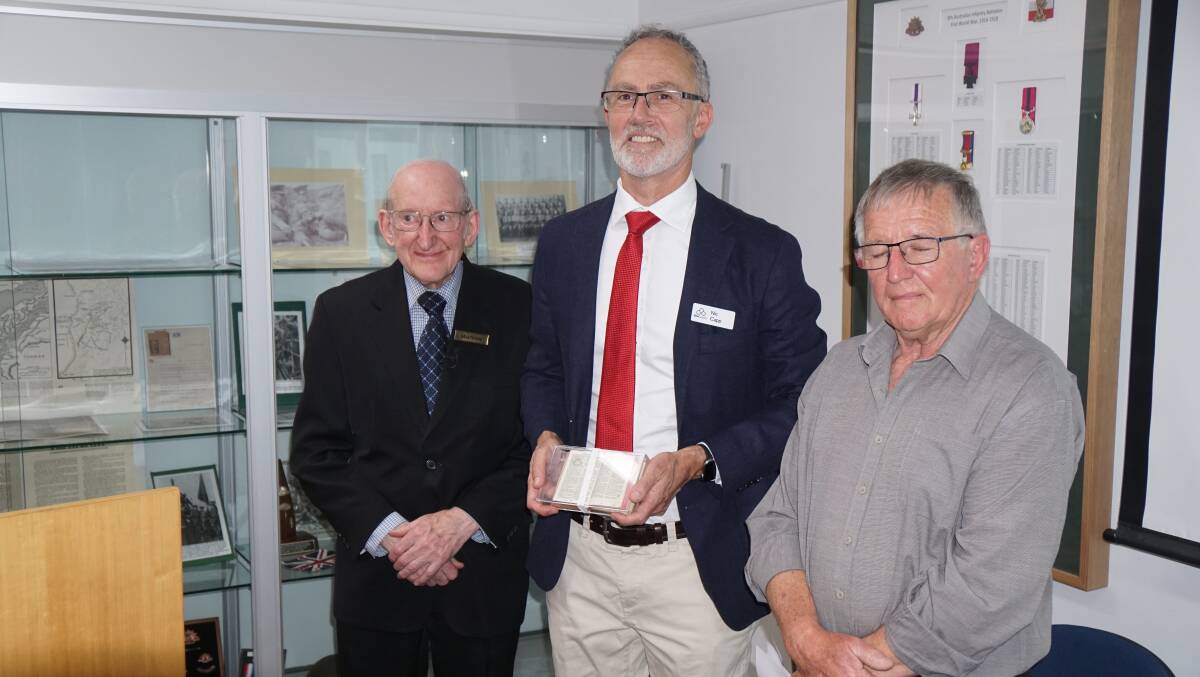 Co-Executors of Richard Davies estate Max White and Des York after presenting Bible Society's Nic Capp with the bible in a glass case. Picture via the Bible Society
