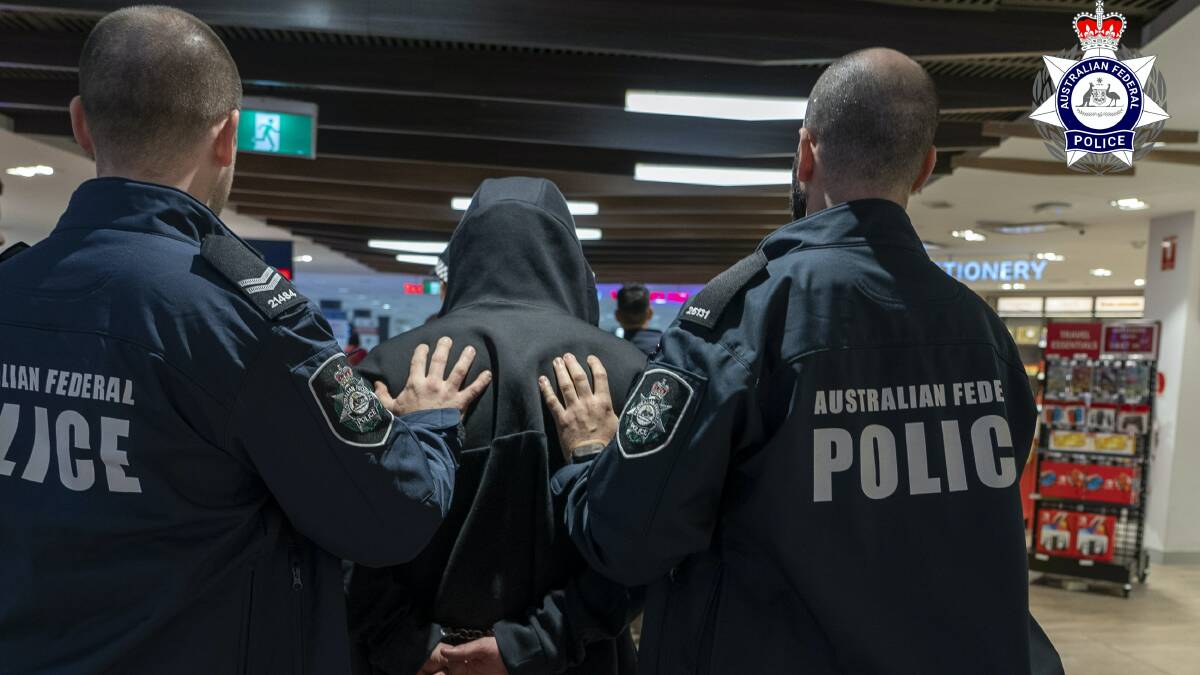 Australian federal Police walk the alleged drug smuggler through Sydney International airport after his arrest on May 27. Picture via AFP