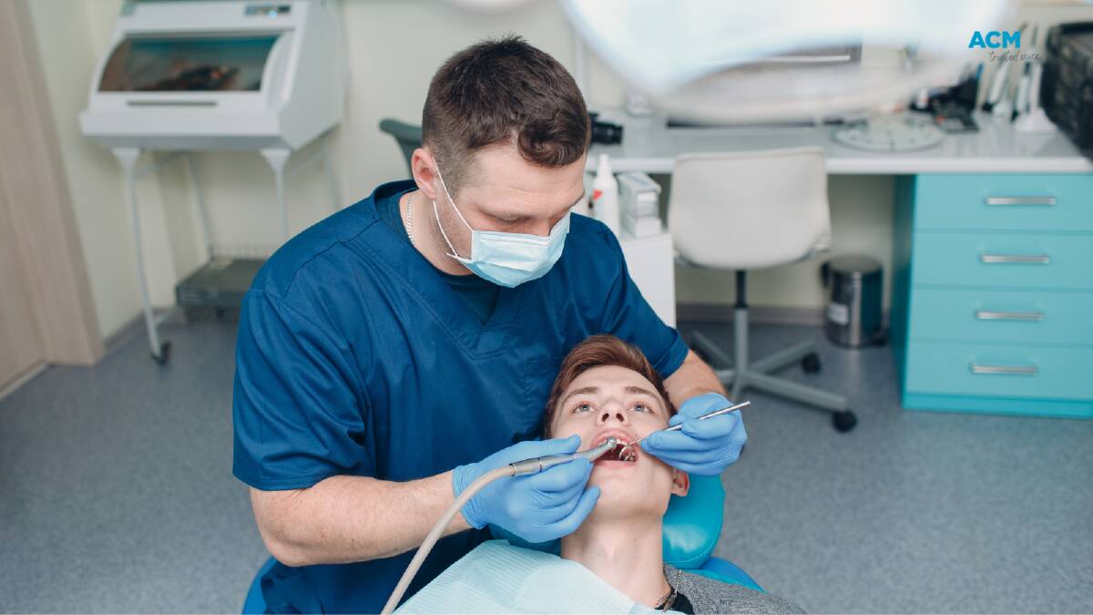 A dentist works on the mouth of a patient. File picture.