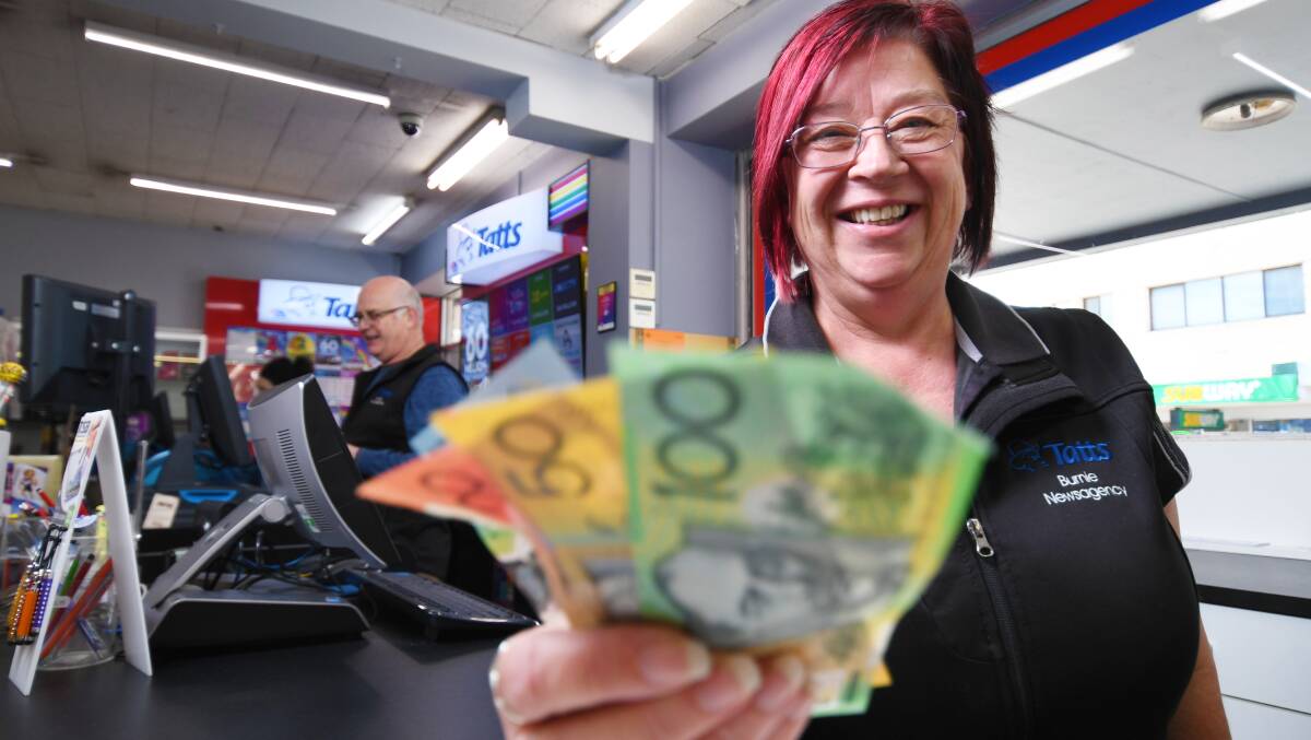 Burnie Newsagency's Michelle Ruffels handing out a wad of cash. Picture by Brodie Weeding