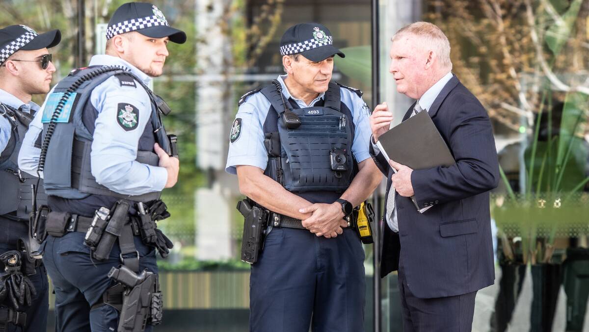 Detective Leading Senior Constable Trent Madders, right, speaks to fellow police officers outside court last year. Picture by Karleen Minney