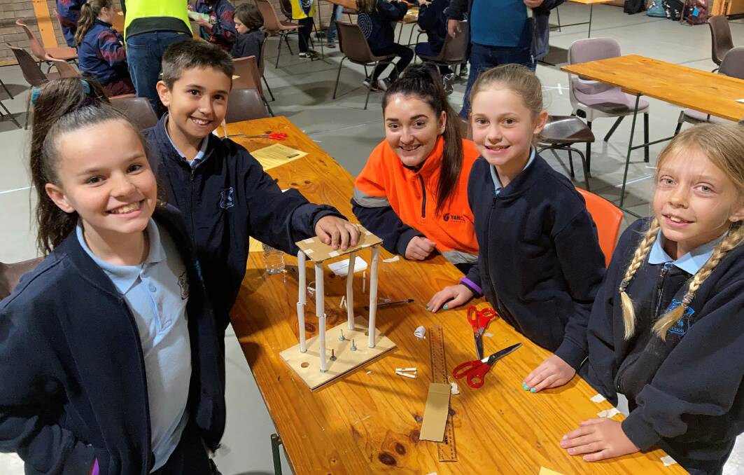 Yancoals Lucy Griffiths and students from Muswellbrook Public School with their structure to test on the University of Newcastles earthquake simulator at the primary school Science and Engineering Discovery Day.