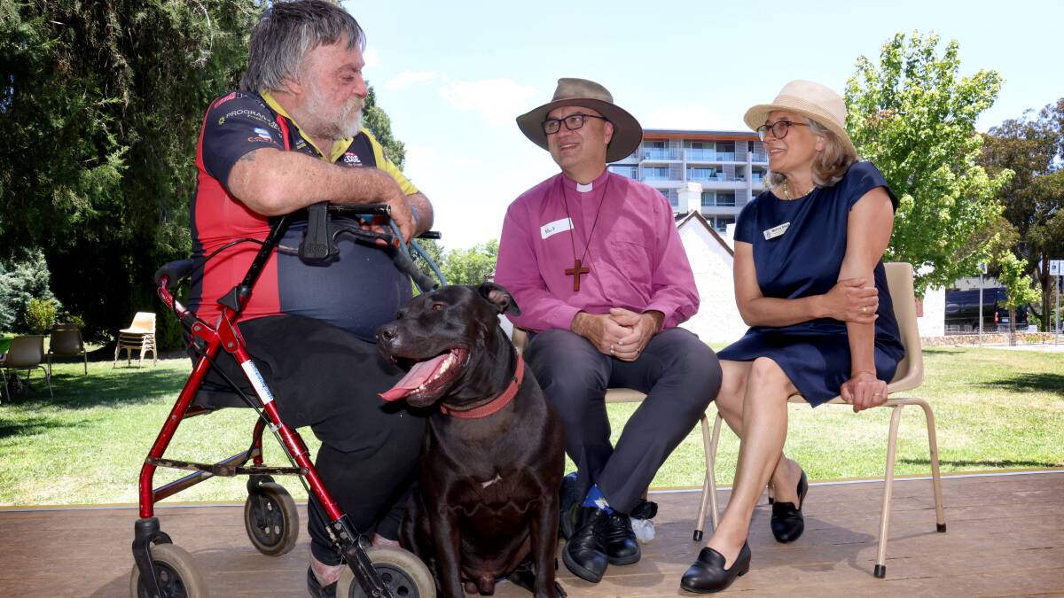 Bishop of Canberra Mark Short and his wife Monica speaking to Peter Fuchs with his dog Alfie at St John's Church Christmas lunch for those in need. Picture by James Croucher