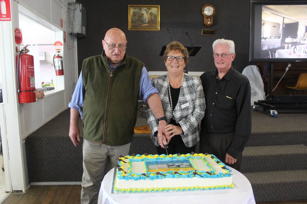 Col Pike and his sister Robyn Wylie with Phil Reid cutting the birthday cake at Bulga Community Centre.