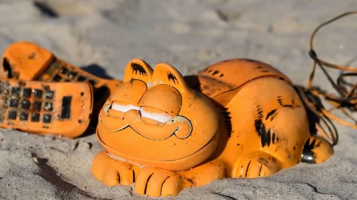 For 35 years, residents of a beachside town in Britanny, France, have dealt with washed up remains of once-popular 1970s-style Garfield phones. It was not until 2019 that the origins of the mysterious plastic phones was discovered. Picture by TIME Magazine.