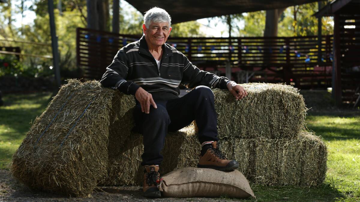 SUPPORT: Rugby league great and Maitland Community Men's Shed member John King with the first bales of hay and grain donated. Picture: Simone De Peak
