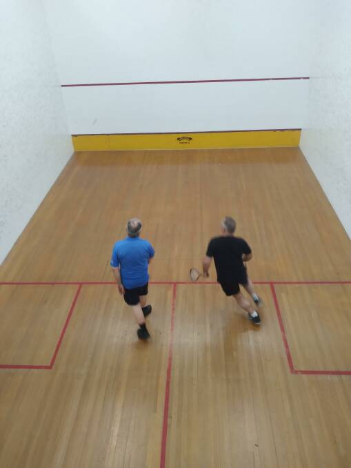 Daryl Coveny (blue) sending Alex Newton (black) off for a run. Alex took the match in an exhausting fifth set.