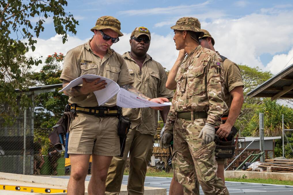 Australian Army Sapper Cameron Turner, checks the construction work site plan with his team. Picture by Sergeant Nunu Campos, Australian Army.