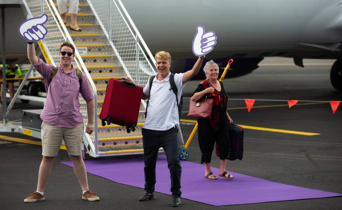 June Doyle touches down in Newcastle as fellow passengers Jack Coffey and Caleb Brown celebrate on the tarmac. Picture by Jonathan Carroll