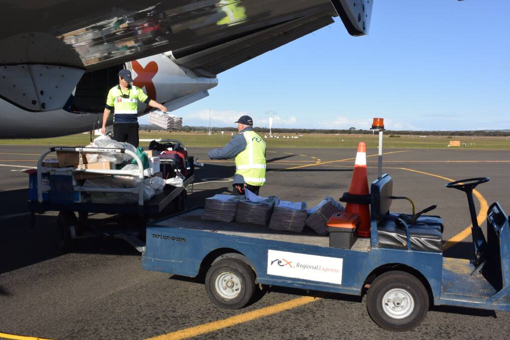 AIR MAIL: Rex airlines apron staff collect last week's Islander newspaper from the hold of the morning plane from Adelaide. Photo: Stan Gorton 