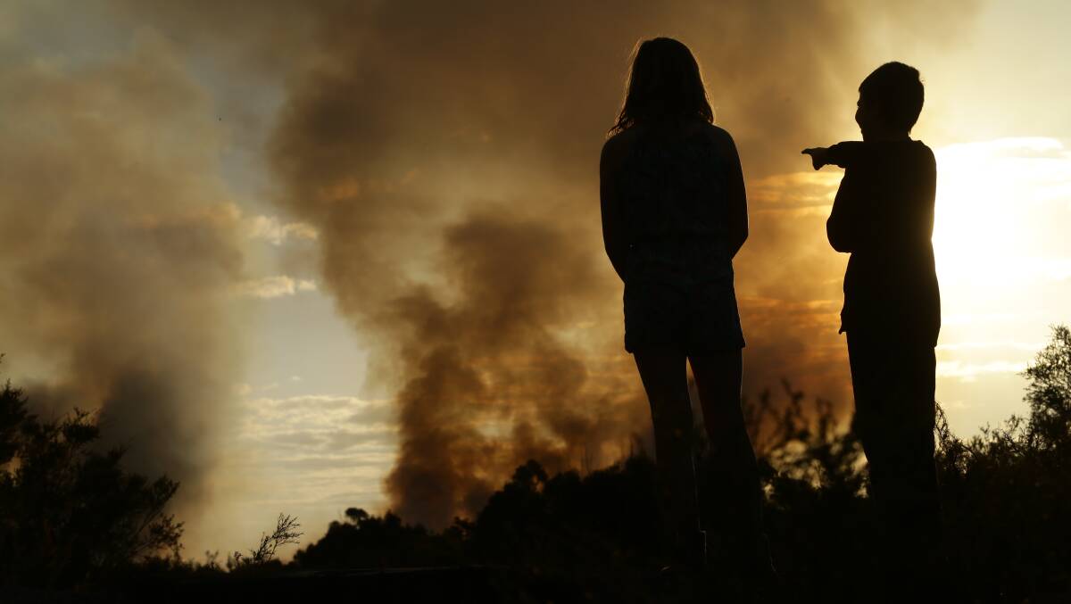 Children watching a bushfire at Port Stephens in 2017. Picture by Jonathan Carroll