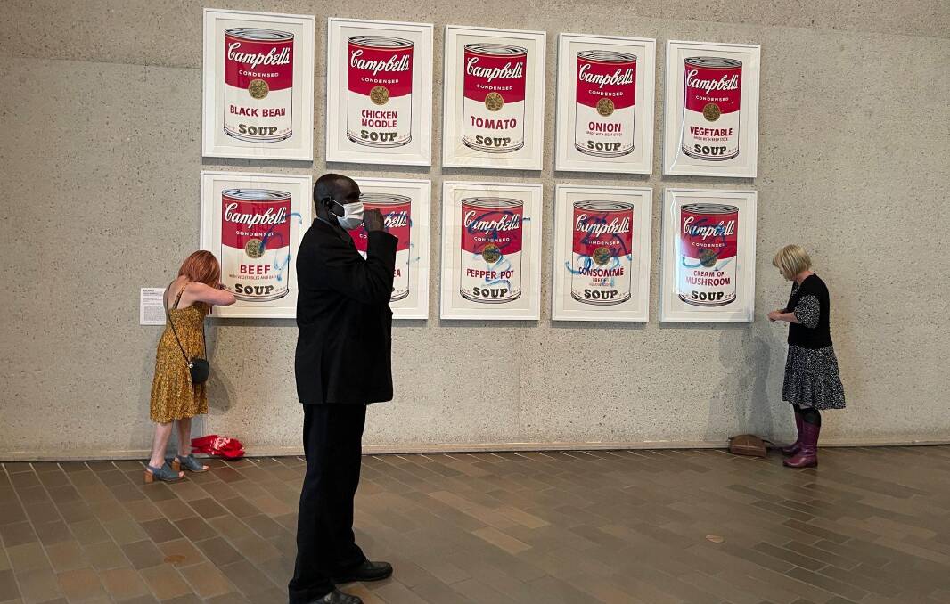 Members of Stop Fossil Fuel Subsidies scrawl across Andy Warhol's Campbell's Soup Cans. Picture supplied 
