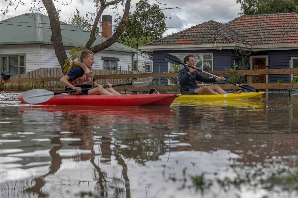 Residents paddle through floodwaters in Melbourne. Picture Getty Images