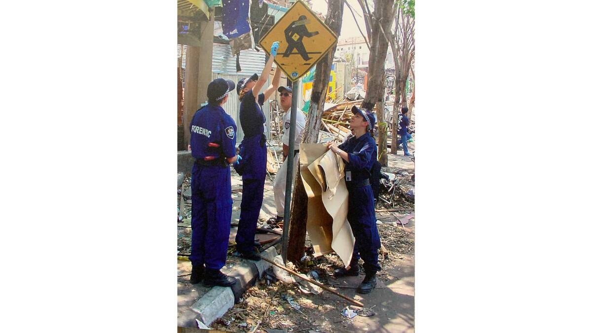 The explosives investigation team, with Sarah Benson at right, swiped the street signs in Kuta near the bomb site to obtain residues. Picture AFP 