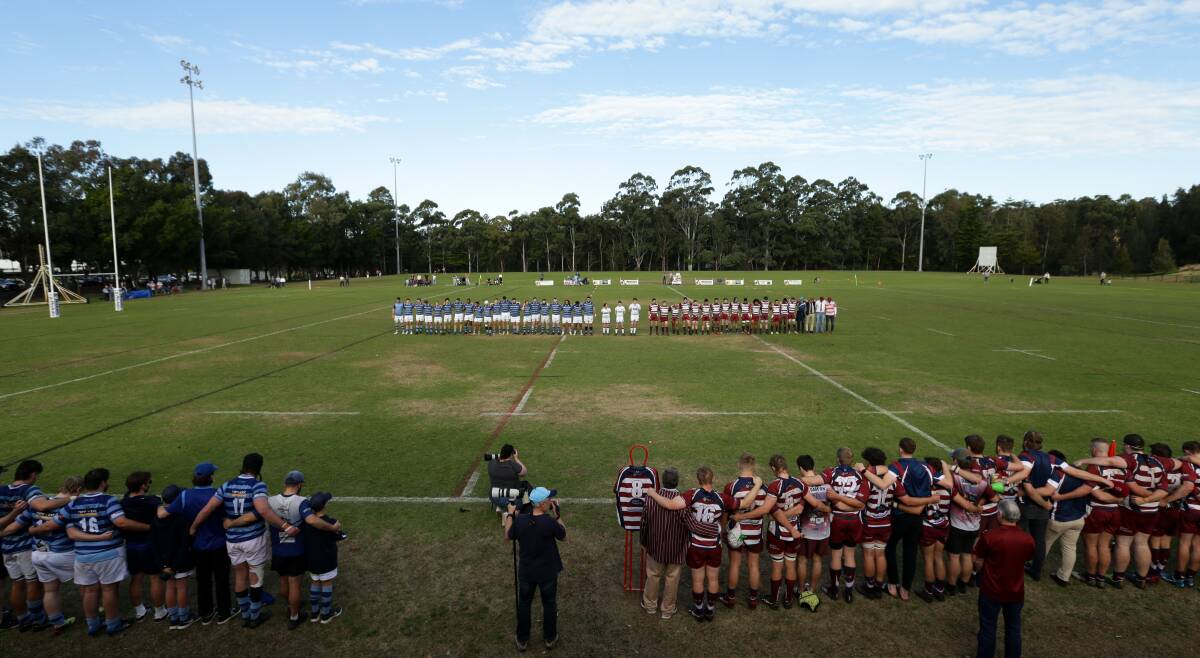 TRIBUTE: Teams and spectators observe a minute's silence in honour of Bernie Curran at Saturday's rugby union match. Picture: Jonathan Carroll 