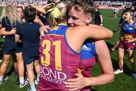 Dakota Davidson (R) hugs Taylor Smith after playing a vital role in Brisbane's grand final triumph. (Joel Carrett/AAP PHOTOS)