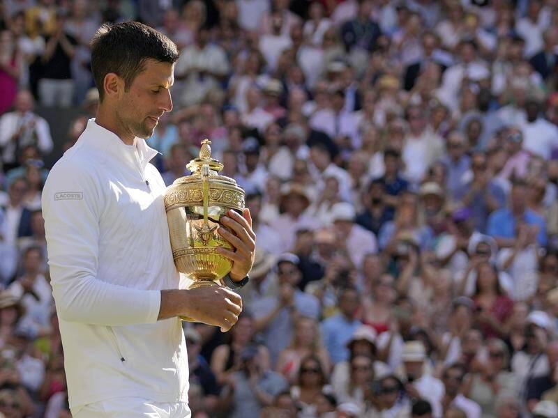 Serbia's Novak Djokovic holds the Challenge Cup as Wimbledon champion for the seventh time.