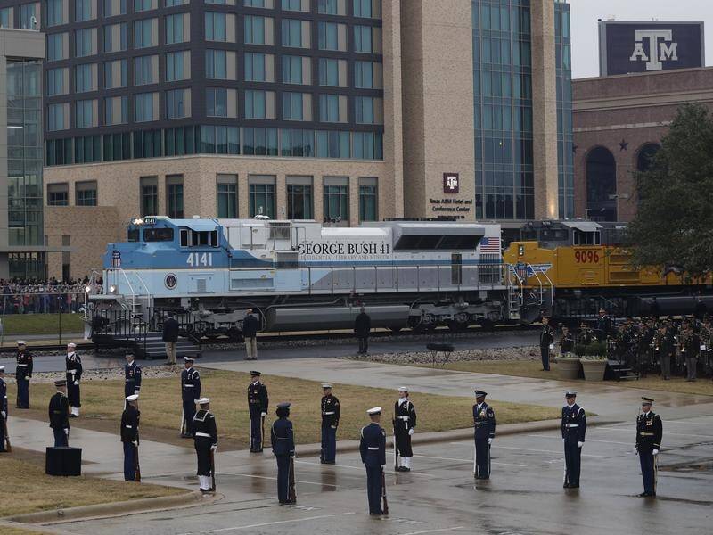 Thousands have greeted the train carrying the body of George HW Bush as it travelled though Texas.
