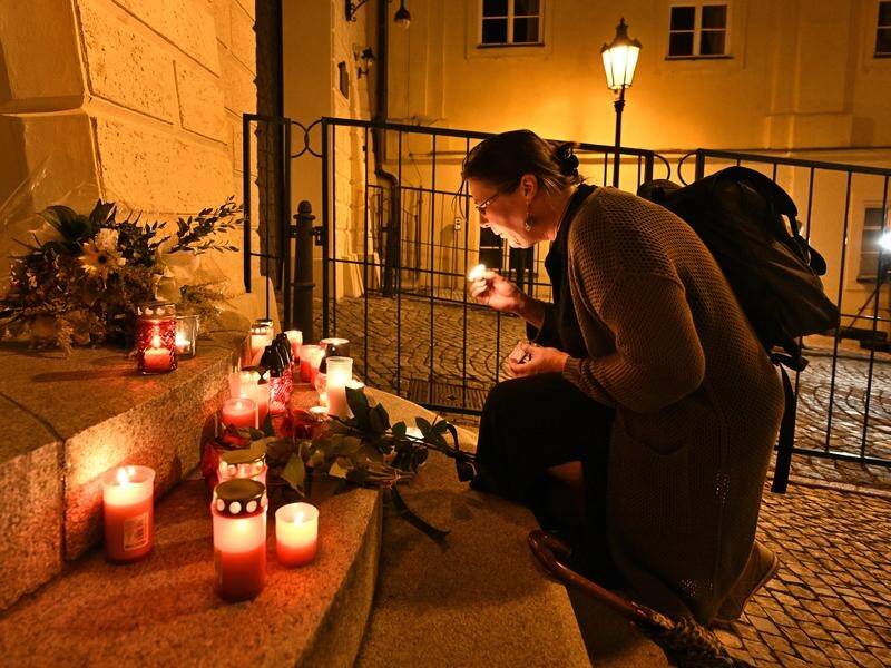 A woman lights a candle in front of the UK embassy in the Czech Republic after the Queen's death. (AP PHOTO)