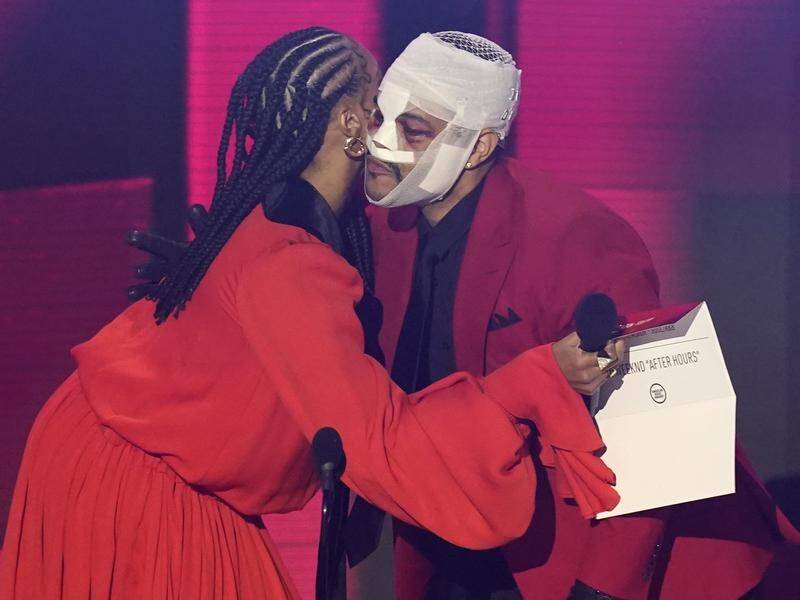 The Weeknd gave no reason for his heavily bandaged appearance at the American Music Awards.