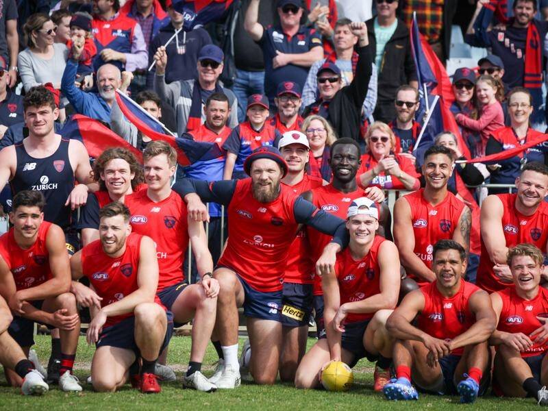 Melbourne players enjoy a team photo with fans at training in Perth ahead of the AFL grand final.