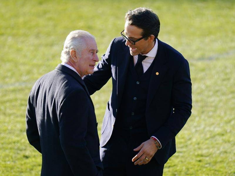 King Charles III speaking to Wrexham co-owner Ryan Reynolds on his visit to the Welsh soccer club. (AP PHOTO)