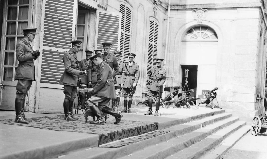 HONOUR: King George V knights Lieutenant General John Monash at the Australian Corps headquarters in France on August 12, 1918. Photo: AWM E02964.