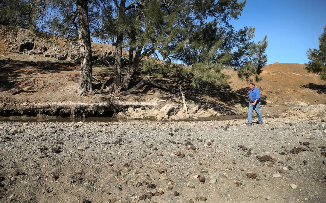 Dry: Cattle farmer James Archibald walks along the bed of the Isis River, which used to run through his property - when it last ran in March, 2017. Picture: Marina Neil