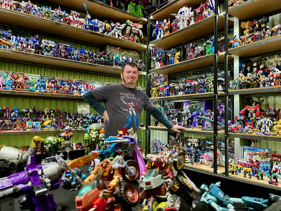 Trevor poses in front of his Transformers collection. Photo: Benjamin Palmer
