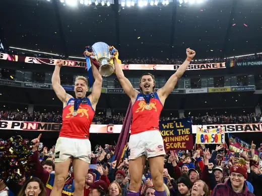 Oscar Allen and Sam Draper enjoying the sweet taste of grand-final success at the MCG. Photo: Joel Carrett/AAP PHOTOS